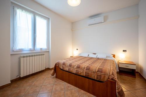 a bedroom with a bed and a large window at My Holidays New Eden Mansarda in Domaso