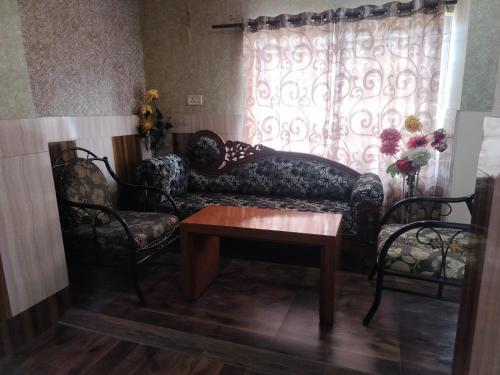 a living room with a couch and two chairs and a table at Hotel Nagaon Point in Nowgong