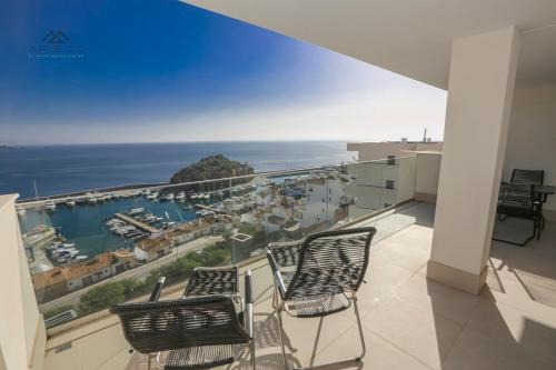 a balcony with two chairs and a view of the ocean at Icon Luxury Seaview Marina in Almuñécar