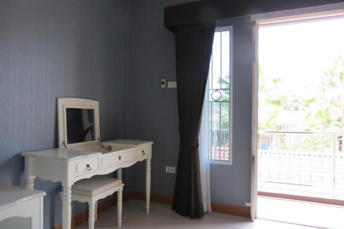 a bathroom with a vanity and a mirror and a window at Baan Bee Residence in Nong Prue