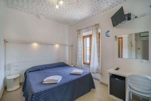 una camera con letto blu e lavandino di La Terrazza sul Mare - Elba Affitti a Porto Azzurro