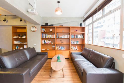 a living room with a leather couch and a table at Check Inn HK in Hong Kong