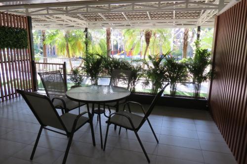 a table and chairs in a room with a patio at Baan Bee Residence in Nong Prue