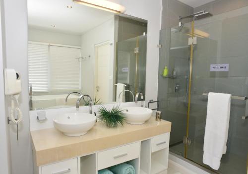 a bathroom with two sinks and a shower at Paradise Beach Luxury Beachfront Apartment Pointe d'Esny in Pointe d'Esny