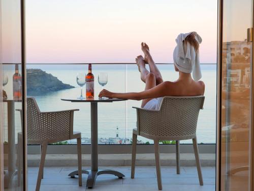 a woman sitting at a table with wine glasses at Blue Bay Lifestyle - ex Bali Blue Bay in Balíon