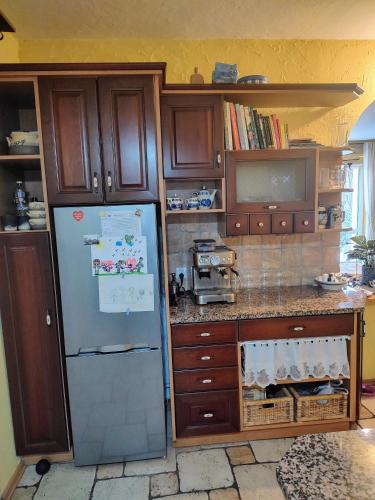 a kitchen with a refrigerator and wooden cabinets at Słoneczne apartamenty in Sobótka