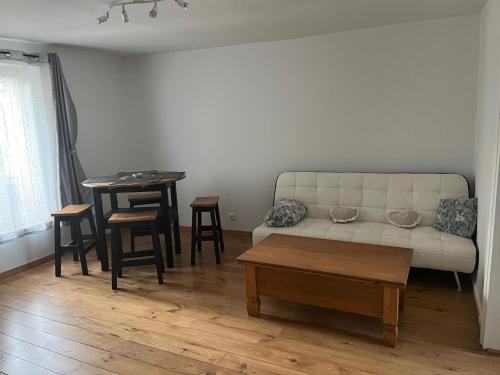 a living room with a couch and a table at Appartement cosy in Châteauneuf-en-Thymerais