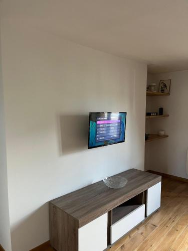 a living room with a tv on a white wall at Appartement cosy in Châteauneuf-en-Thymerais