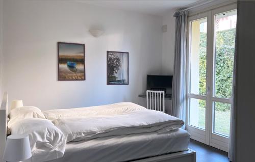 una camera da letto bianca con un letto e una finestra di La piccola coccinella a Bellagio