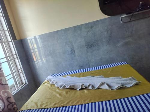 a bed with a napkin on it in a room at Hotel Nagaon Point in Nowgong
