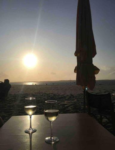 two glasses of wine sitting on a table at the beach at Maison Eysines- A10 in Eysines