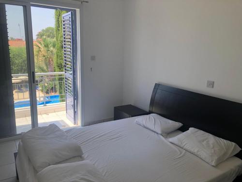 ein Schlafzimmer mit einem Bett und einem großen Fenster in der Unterkunft Sunny Paphos in Anarita