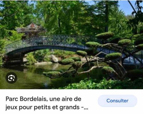 a bridge over a pond in a garden with trees at Maison Eysines- A10 in Eysines
