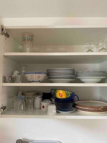 a cabinet filled with plates and bowls and dishes at Maison Eysines- A10 in Eysines