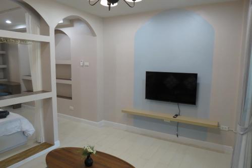 a living room with a flat screen tv on a wall at Baan Bee Residence in Nong Prue