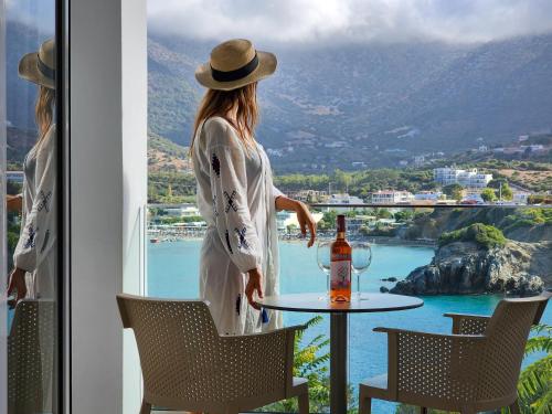 a woman standing at a table with a bottle of wine at Blue Bay Lifestyle - ex Bali Blue Bay in Balíon