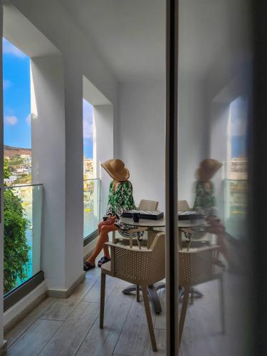 two women in straw hats sitting at tables looking out the window at Blue Bay Lifestyle - ex Bali Blue Bay in Balíon