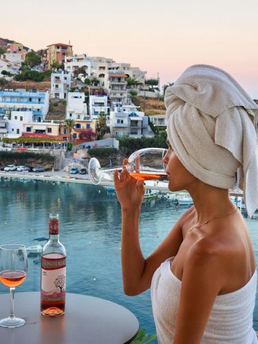a woman drinking a glass of wine next to the water at Blue Bay Lifestyle - ex Bali Blue Bay in Balíon