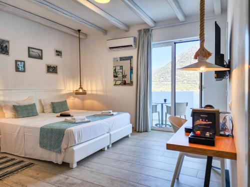 a bedroom with a bed and a table and a tv at Blue Bay Lifestyle - ex Bali Blue Bay in Balíon