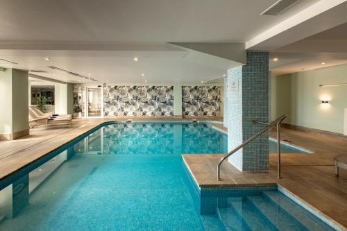 a swimming pool with blue tiles in a building at Waterfront in Sliema