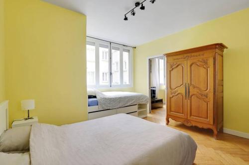 une chambre avec un lit et une armoire en bois dans l'établissement Bright getaway near Montparnasse, à Paris