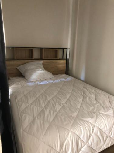 - un lit blanc avec une tête de lit en bois dans l'établissement Le Paul Bert, à Tours