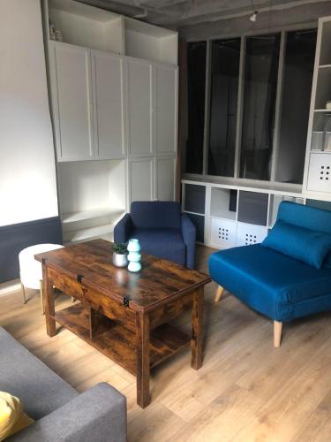 - un salon avec une table basse et des canapés bleus dans l'établissement Le Paul Bert, à Tours