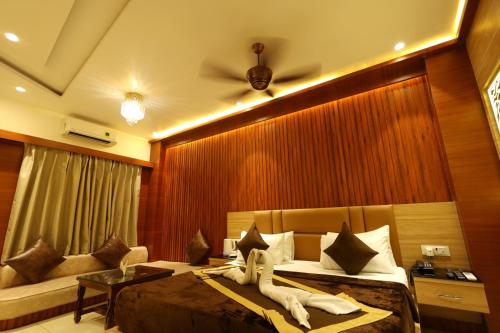 a hotel room with a bed and a couch at Hotel Darbar-E-Khas in Bareilly