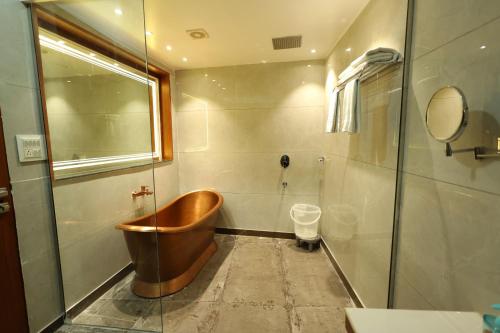 a bathroom with a wooden tub and a shower at Hotel Darbar-E-Khas in Bareilly