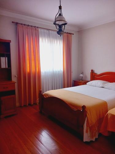 a bedroom with a large bed and a window at Casa Rua dos Loureiros in Marco de Canaveses