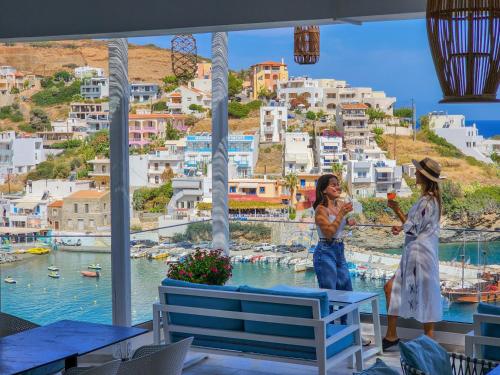 two women standing in a room with a view of a city at Blue Bay Lifestyle - ex Bali Blue Bay in Balíon