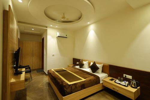 a hotel room with a bed and a television at Hotel Darbar-E-Khas in Bareilly