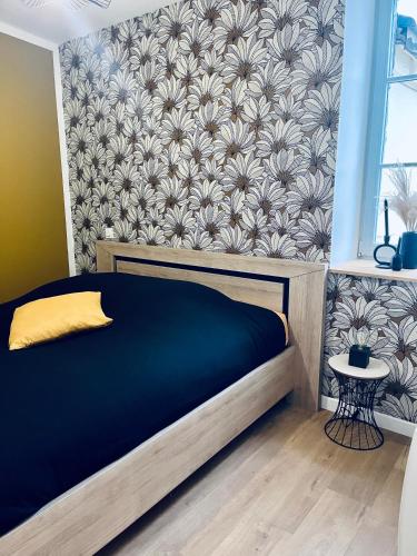 - une chambre avec un lit et un mur orné de fleurs dans l'établissement Le Pattulacci, à Rocroi
