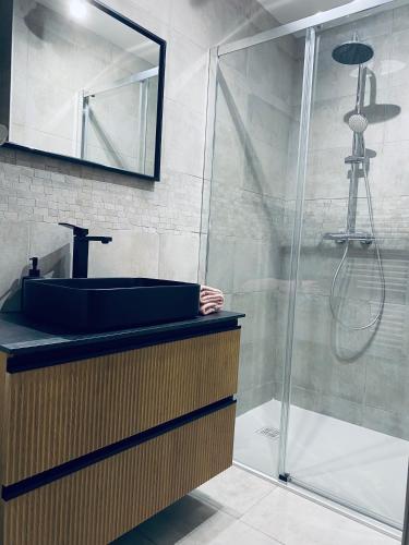 une salle de bain avec un lavabo et une douche dans l'établissement Le Pattulacci, à Rocroi