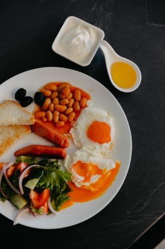 a plate of food with eggs and vegetables on a table at Апарт-отель Tong Marina in Tong