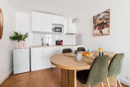 a kitchen and dining room with a wooden table and chairs at Duplex moderne proche metro - Mairie des Lilas - FLAT-GUEST in Les Lilas