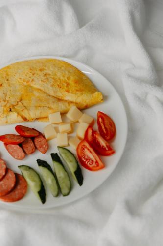 a plate of food with tomatoes cucumbers and cheese at Апарт-отель Tong Marina in Tong