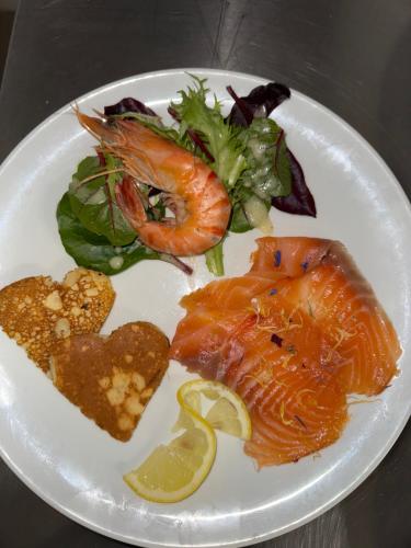 a plate of food with fish and a salad at Logis La Venise Verte in Soulaines-Dhuys