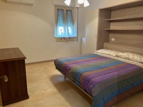 a bedroom with a bed and a table and a window at la casa della nonna in Collazzone