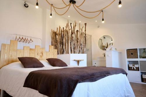 une chambre avec un grand lit avec une tête de lit en bois dans l'établissement Duplex rénové U Fragnu, à Prunelli-di-Fiumorbo