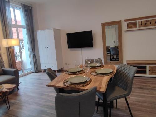 a living room with a wooden table and chairs at Villa Boberg Apartments in Ostseebad Koserow