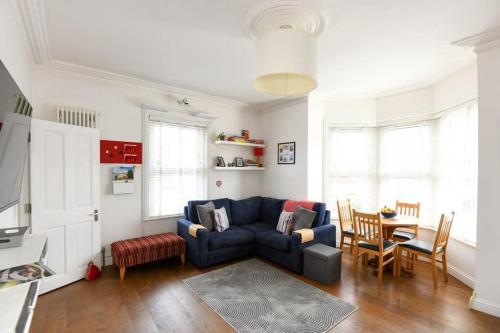 a living room with a blue couch and a table at Modern Southville Apartment 5 Min Walk to Centre in Bristol