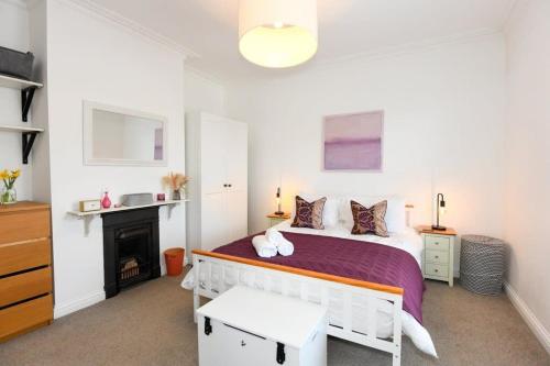 a white bedroom with a bed and a fireplace at Modern Southville Apartment 5 Min Walk to Centre in Bristol