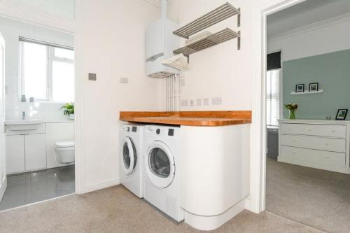 a white laundry room with a washer and dryer at Modern Southville Apartment 5 Min Walk to Centre in Bristol