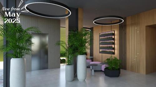 a lobby with two potted plants in a room at Ilirija Resort Hotel Adriatic in Biograd na Moru