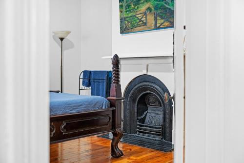 a bedroom with a bed and a fireplace at Character 1880s Renovated Cottage - Quiet location in Adelaide