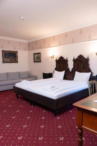 a bedroom with a large bed and a couch at Casa del Sole Boutique Hotel Timisoara in Timişoara