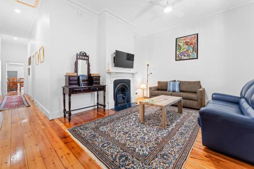 a living room with a blue couch and a fireplace at Character 1880s Renovated Cottage - Quiet location in Adelaide
