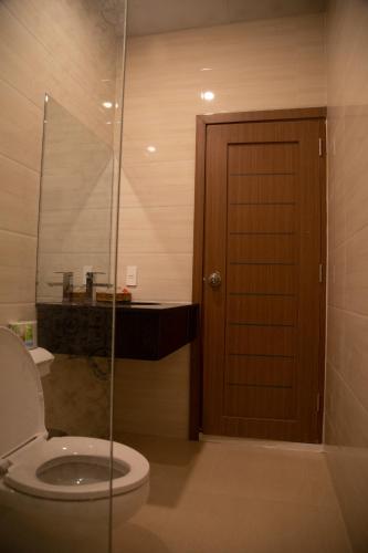 a bathroom with a toilet and a glass door at BaKa Hotel - Khách sạn Tuy Hòa in Liên Trì (3)
