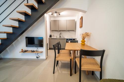 a dining room with a table and chairs and a staircase at Maison alsacienne in Sélestat